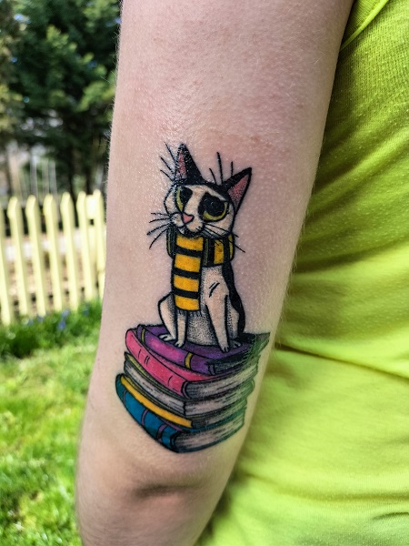 Tatuaż biało-czarnego kotka w czarno-żółtym szaliczku